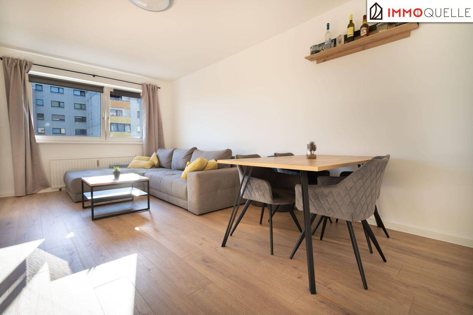 Geräumiges Wohn- und Esszimmer mit Laminatboden, gemütlicher Sitzecke und Essbereich.