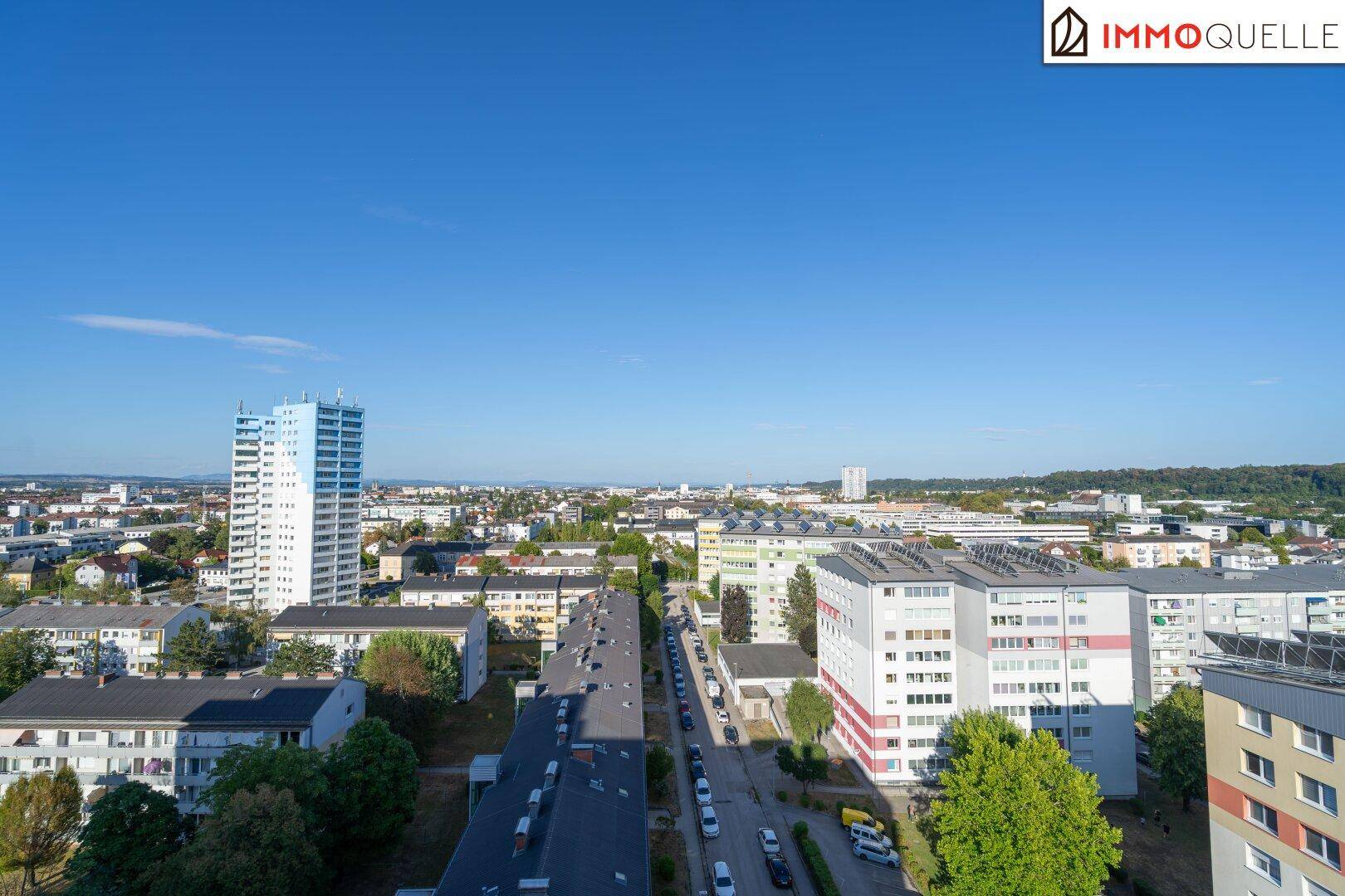 Weitläufiger Blick über die städtische Landschaft mit Wohngebäuden und Straßen.