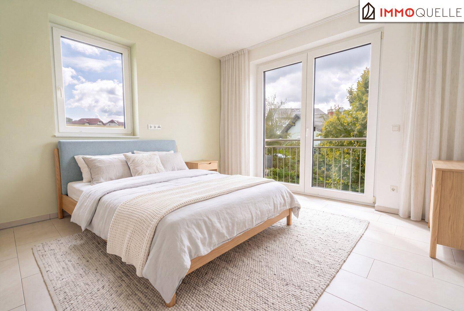 Helles Schlafzimmer mit Doppelbett, Fliesenboden und französischem Balkon.