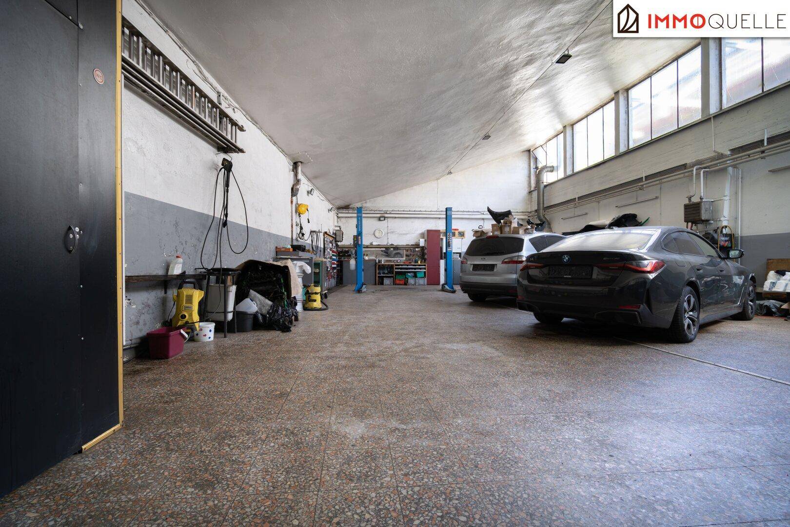 Große Werkstatt mit Hebebühnen und mehreren Fahrzeugen, ideal für Reparaturen und Wartung.