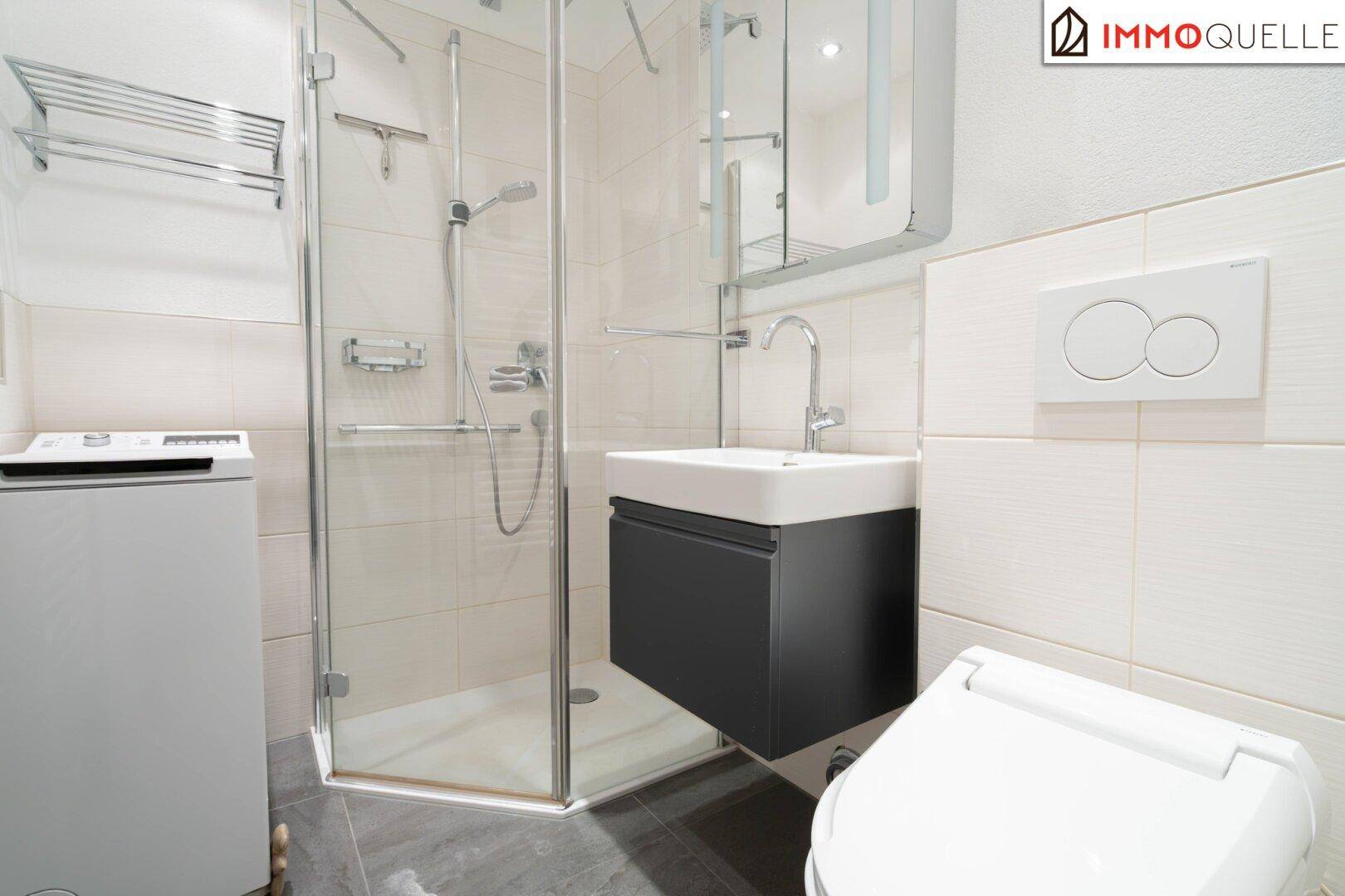 Modernes Badezimmer mit Duschkabine, Hänge-WC, Waschbecken und Fliesenboden.