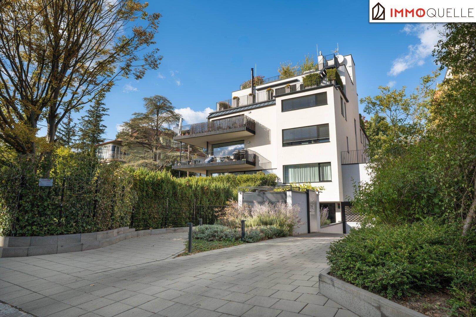 Modernes Mehrfamilienhaus mit mehreren Balkonen und gepflegter Außenanlage.