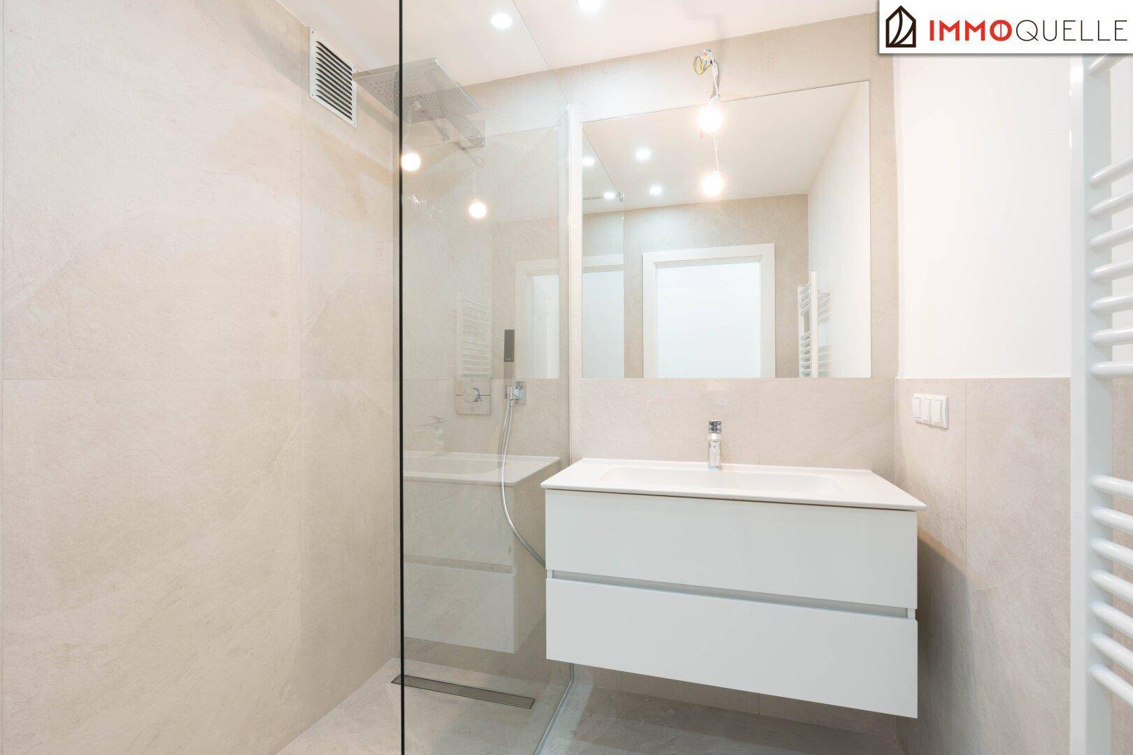 Modernes Badezimmer mit begehbarer Dusche, elegantem Waschtisch und Handtuchheizkörper.