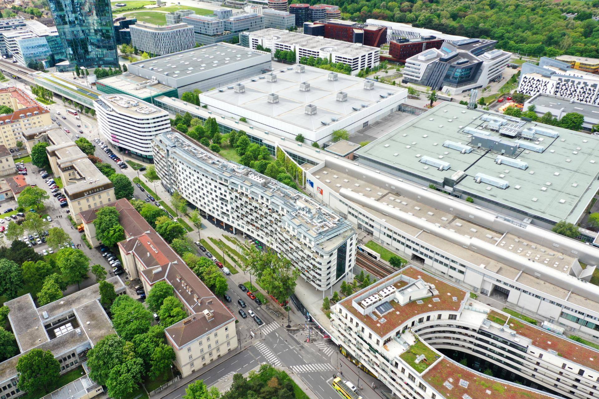 Luftaufnahme eines modernen Wohnkomplexes in einer städtischen Umgebung mit viel Grün und Infrastruktur.
