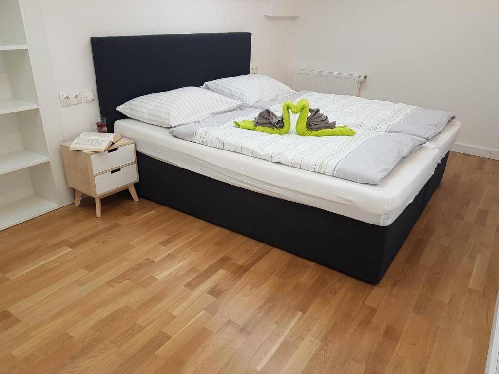 Helles Schlafzimmer mit Doppelbett, Holzboden und Nachttisch.