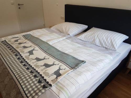 Schlafzimmer mit Doppelbett und traditioneller Hirsch-Decke, auf Holzboden.