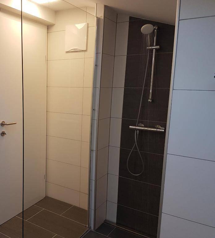 Duschbereich im Badezimmer mit modernen Fliesen und Duscharmatur.