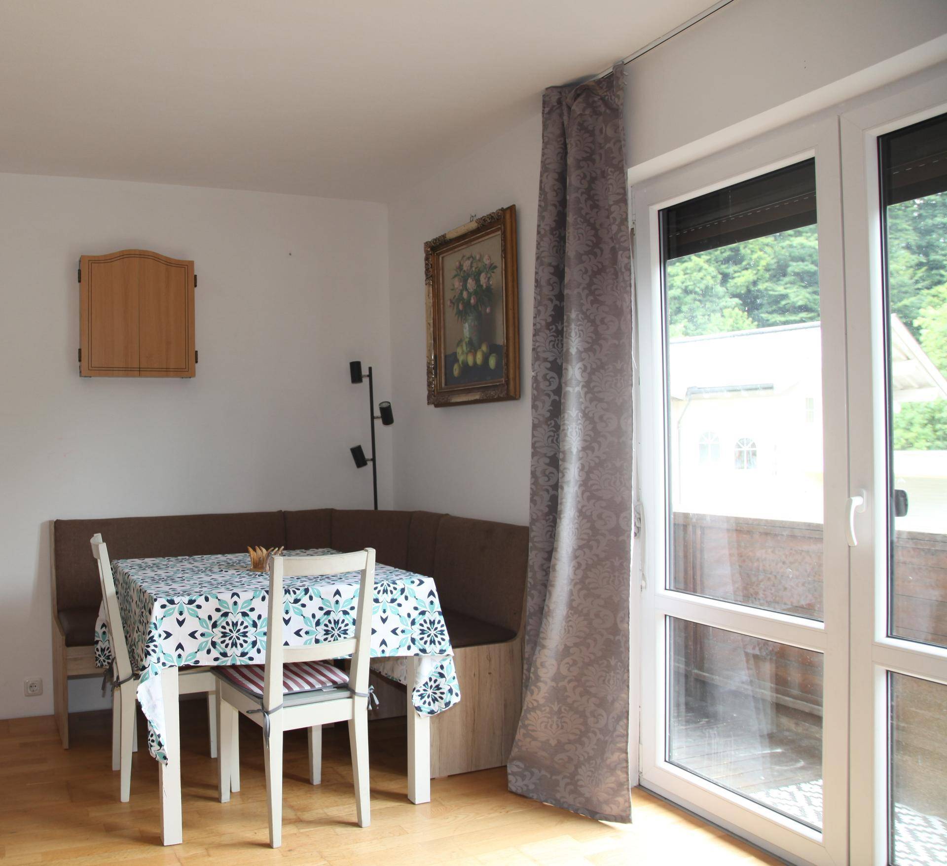 Essbereich mit Eckbank, Esstisch und Zugang zum Balkon.