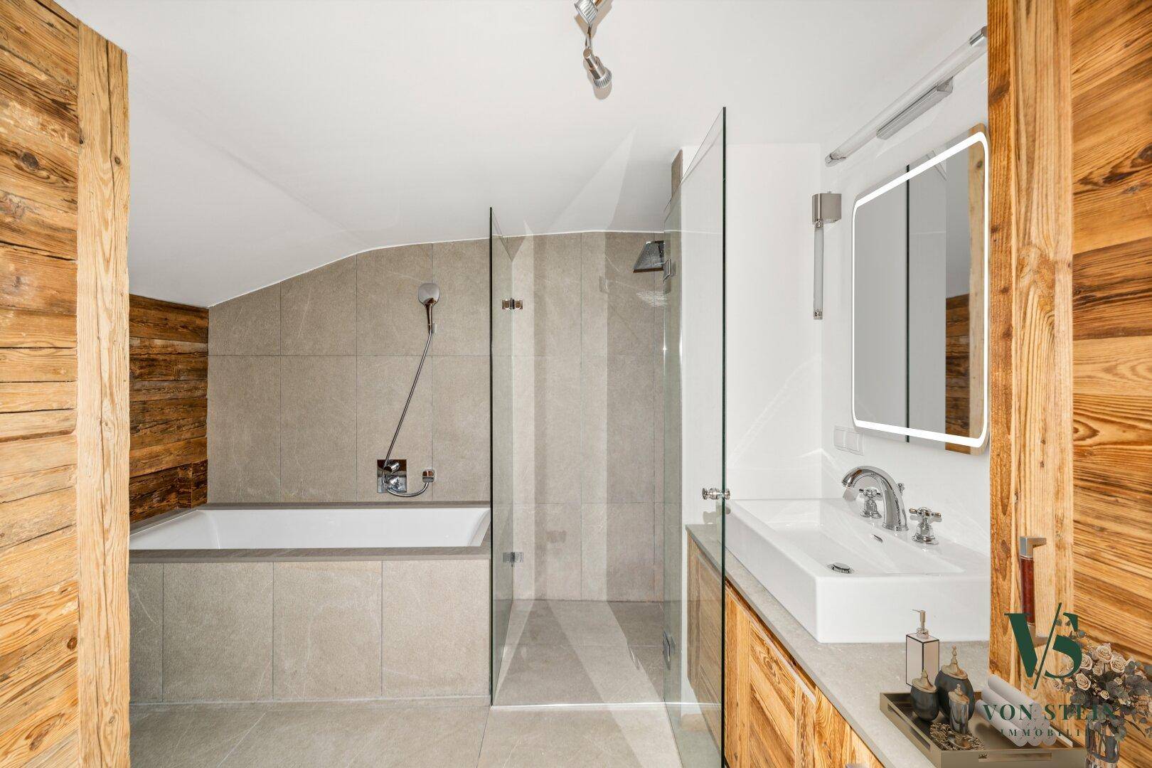 Modernes Badezimmer mit Badewanne, begehbarer Dusche und Holzverkleidung.