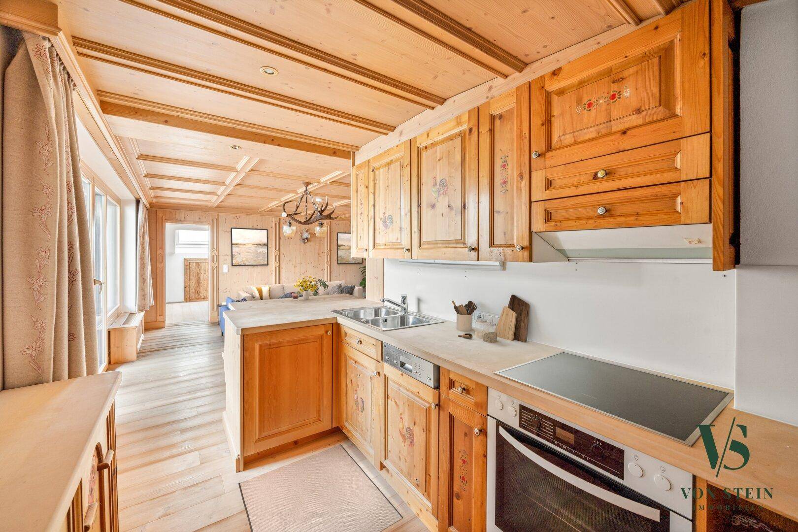 Gemütliche Küche im Landhausstil mit Holzschränken und integrierten Geräten.