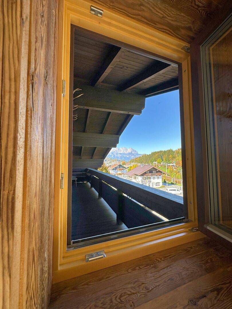 Blick vom Balkon auf die umliegende Berglandschaft und die traditionellen Häuser.