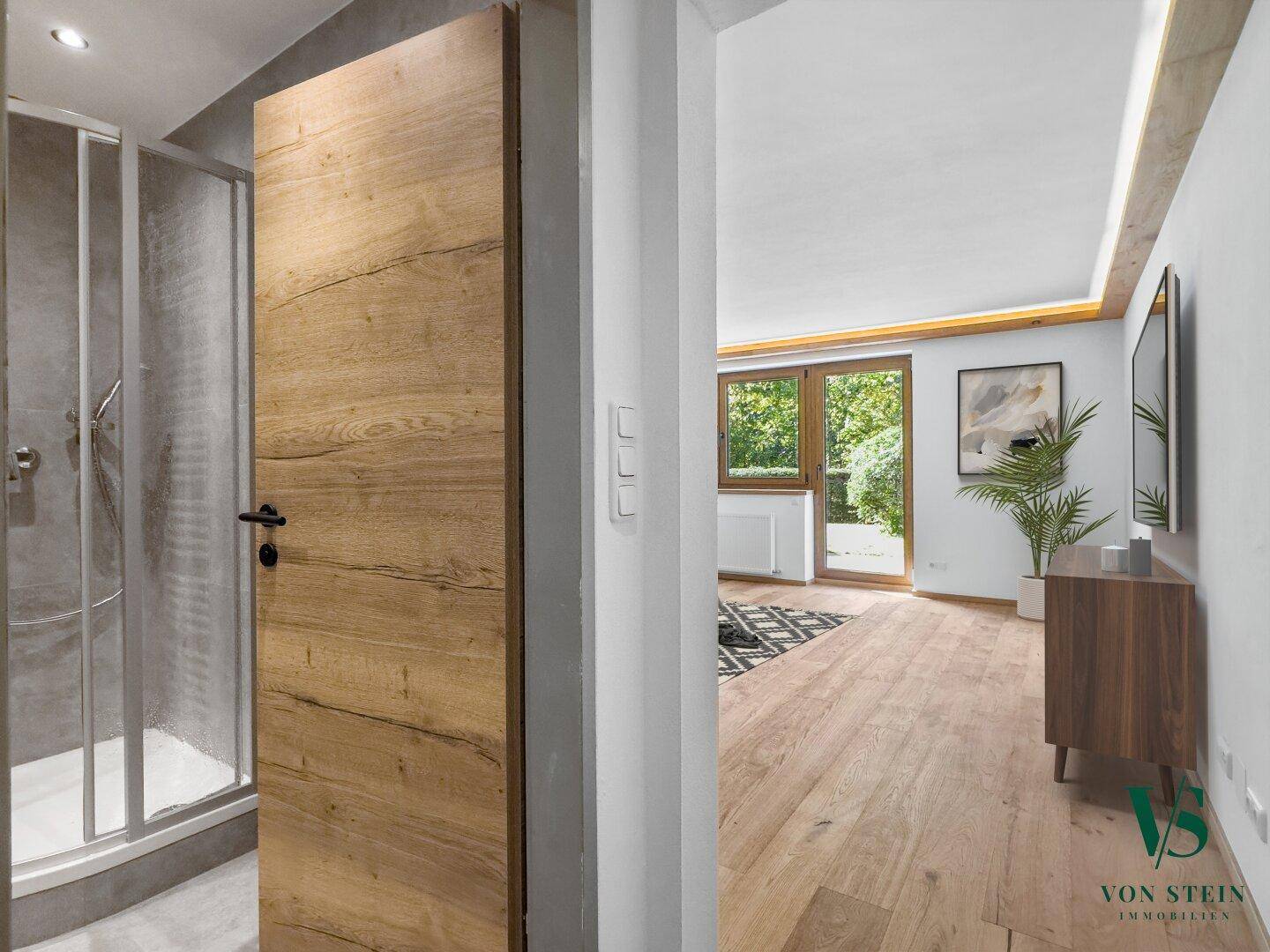 Heller Flur mit Holztür, der zu einem modernen Badezimmer und Wohnbereich führt.