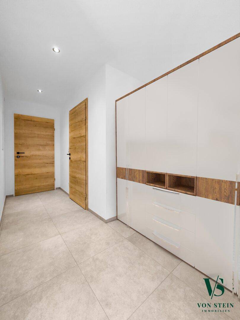 Heller Flur mit integriertem Schrank und modernen Holztüren.