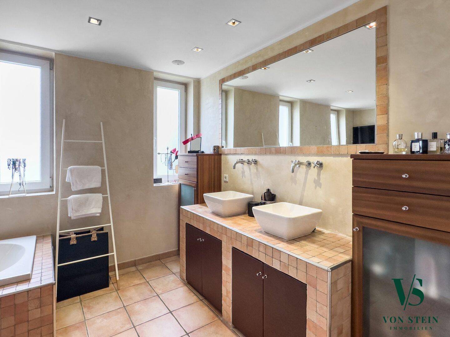 Modernes Badezimmer mit Doppelwaschbecken, großem Spiegel und Fliesenboden.