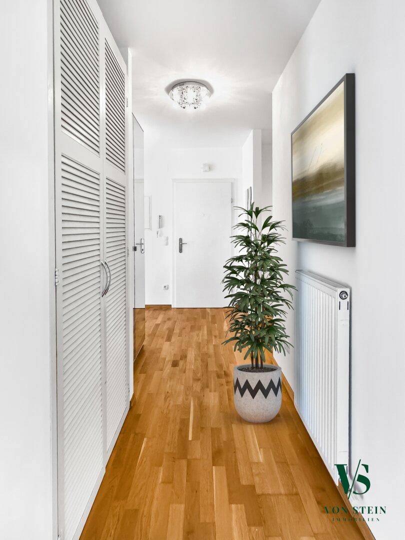 Heller Flur mit Holzfußboden, Einbauschränken und moderner Dekoration.