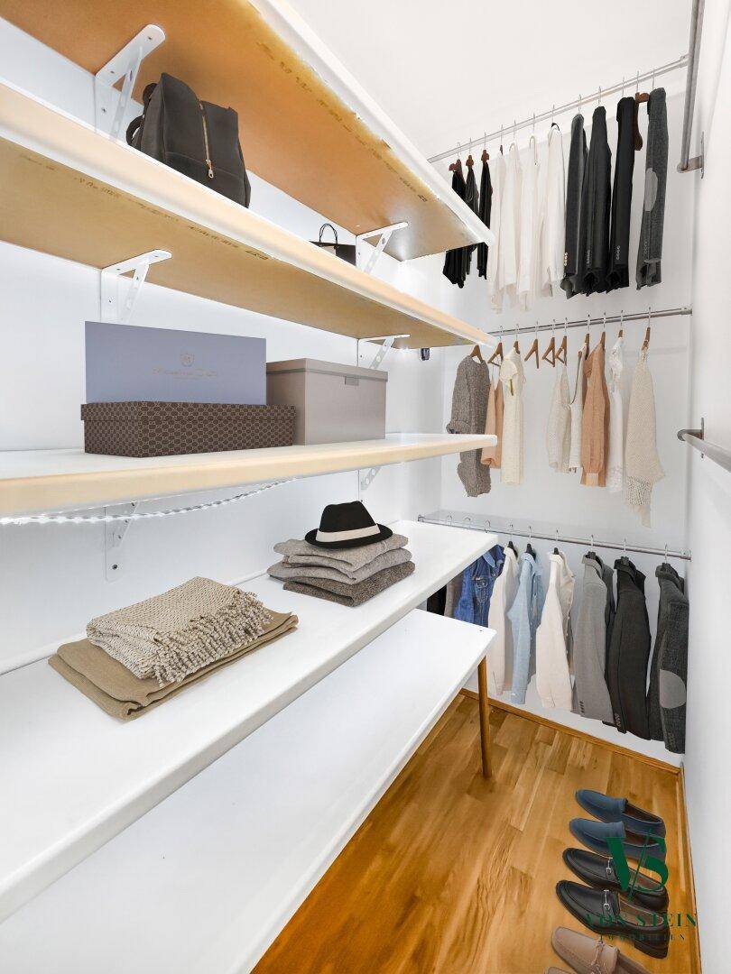 Praktischer begehbarer Kleiderschrank mit Regalen und Kleiderstangen für viel Stauraum.