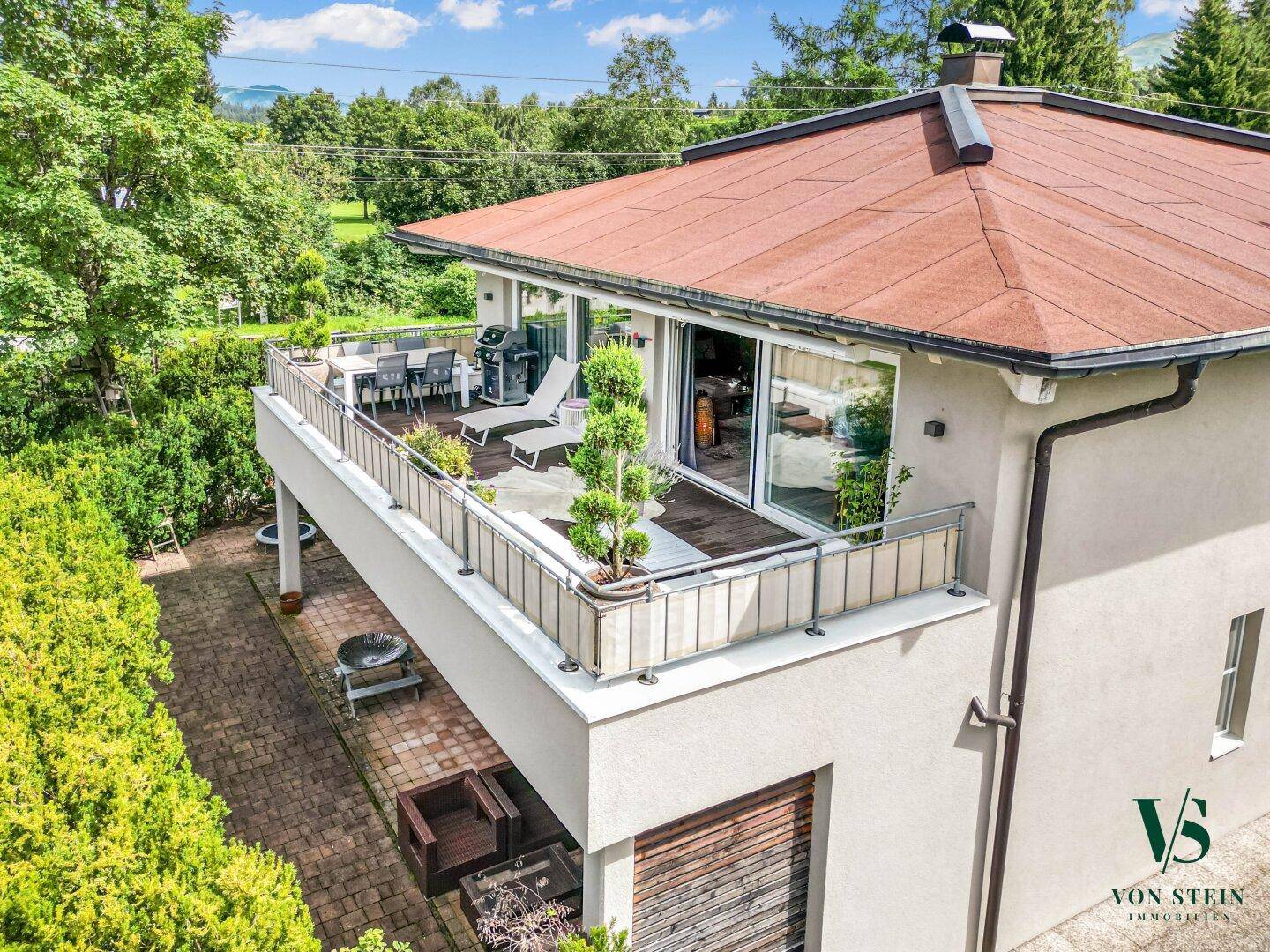 Geräumige Terrasse mit Holzboden und Sitzgelegenheiten, ideal für entspannte Stunden im Freien.