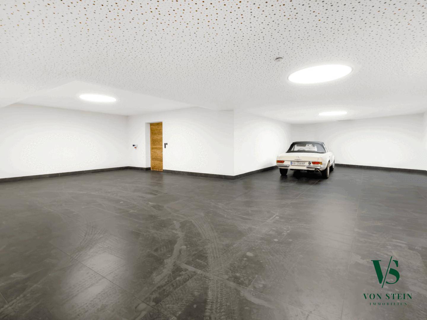 Geräumige Tiefgarage mit ausreichend Platz für mehrere Fahrzeuge und einem Oldtimer.