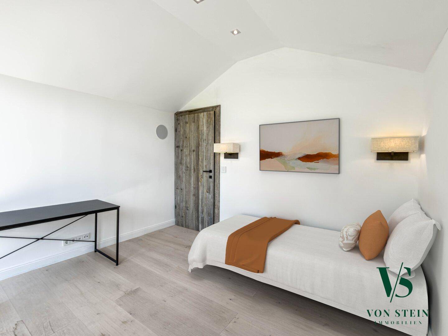 Gemütliches Schlafzimmer mit Einzelbett, Schreibtisch und Holztür unter Dachschräge.