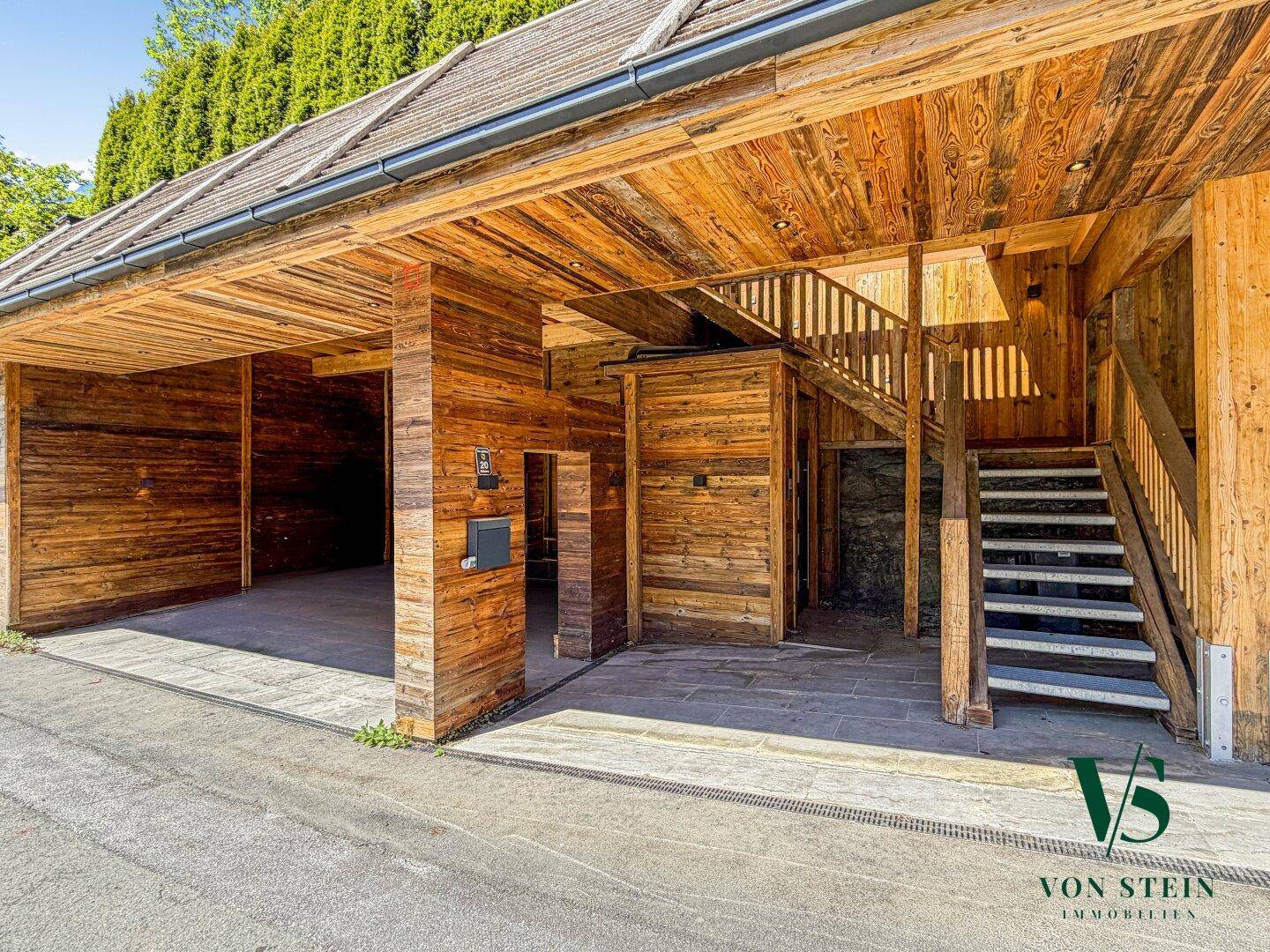 Rustikaler Holzcarport mit Treppenaufgang und viel natürlichem Holz.