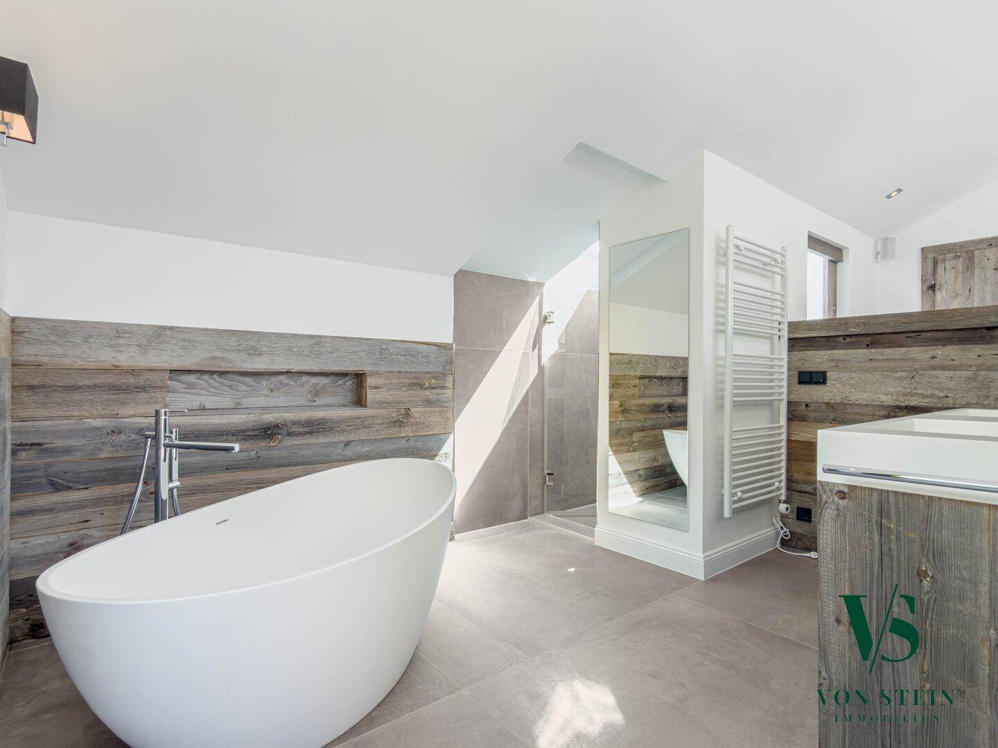 Modernes Badezimmer mit freistehender Badewanne, begehbarer Dusche und Holzakzenten.