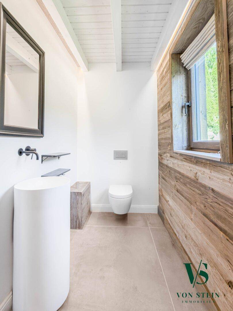 Modernes Gäste-WC mit freistehendem Waschbecken, Wand-WC und Holzwand.