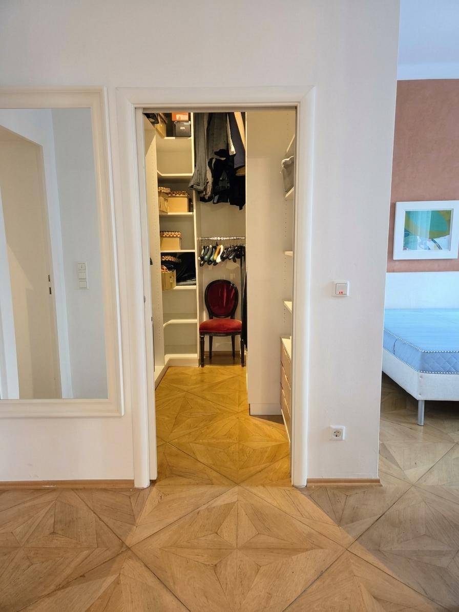 Begehbarer Kleiderschrank mit Regalen und Stauraum, direkt vom Schlafzimmer zugänglich.