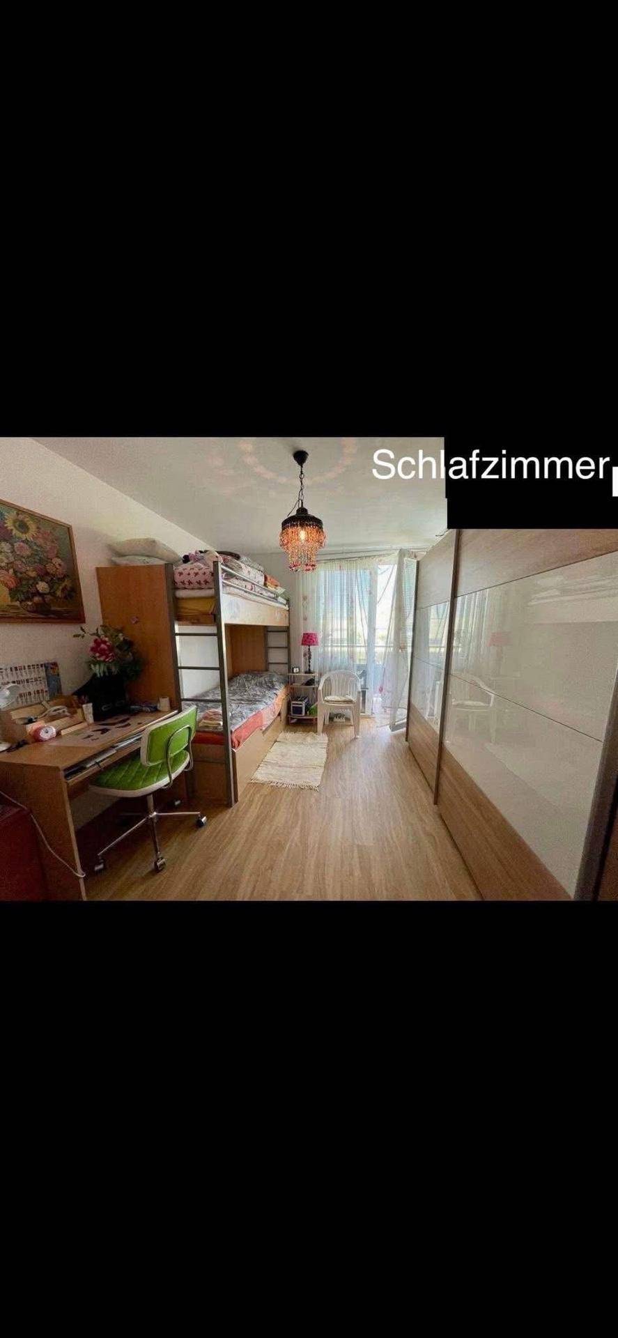 Kinderzimmer mit Etagenbett, Schreibtisch und großem Kleiderschrank, hell und funktional eingerichtet.