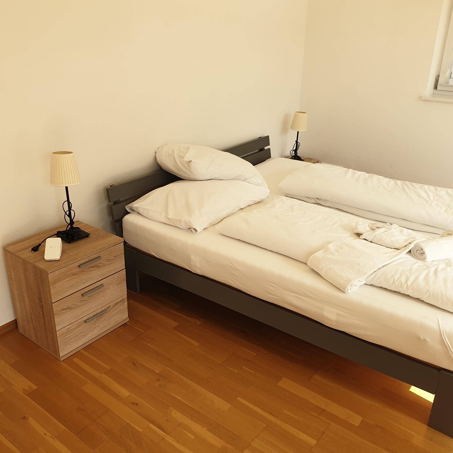 Gemütliches Schlafzimmer mit Holzboden, Doppelbett und Nachttischen.