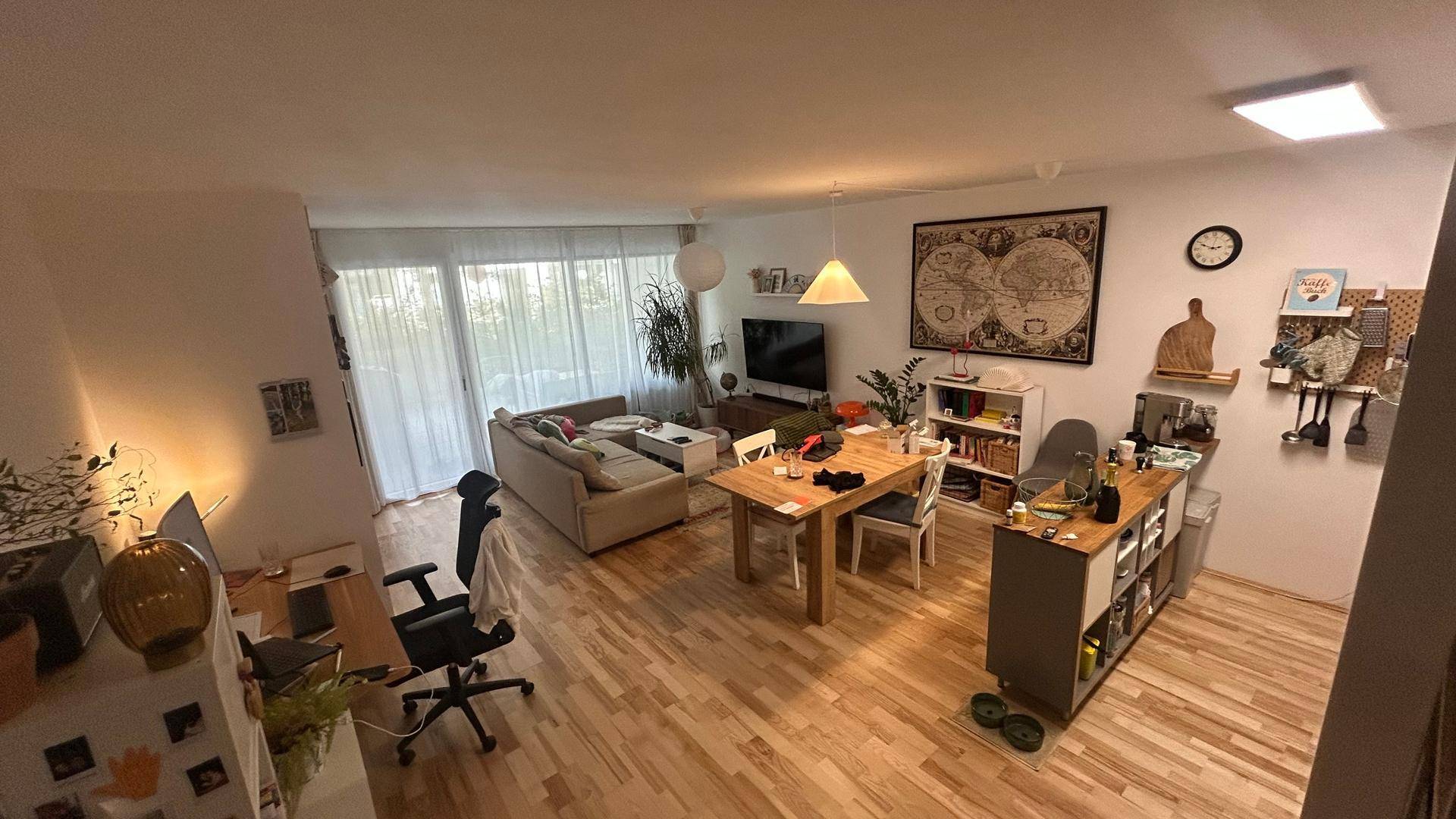 Heller offener Wohn-Essbereich mit Holzboden, modernem Dekor und Zugang zum Balkon.