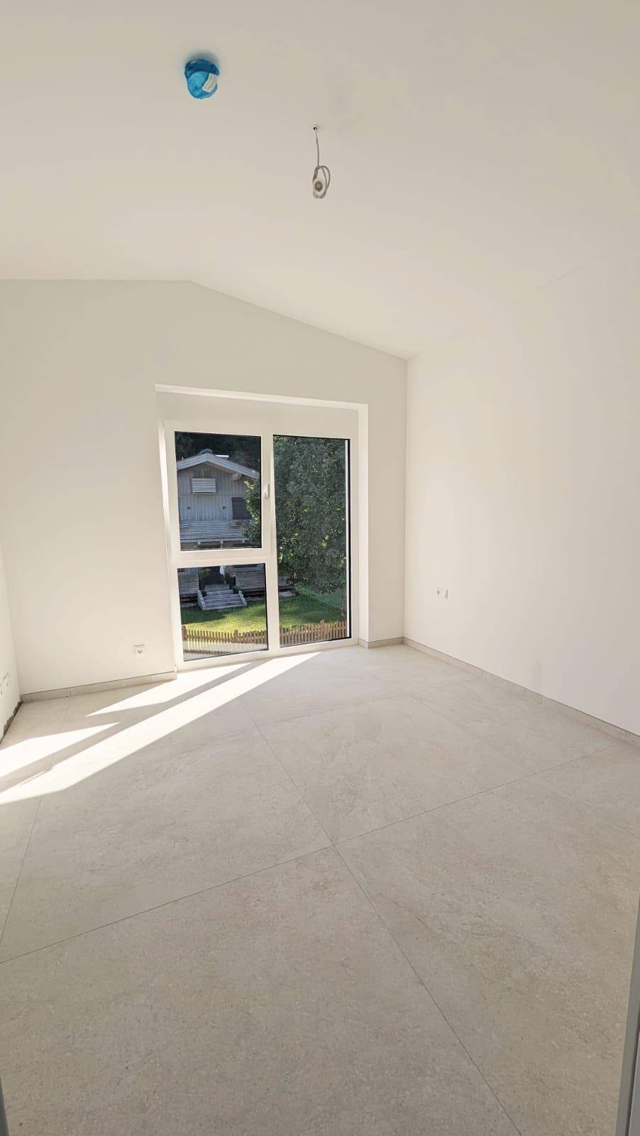 Heller Raum mit schrägen Decken, großen Fenstern und Fliesenboden, ideal für individuelle Gestaltung.