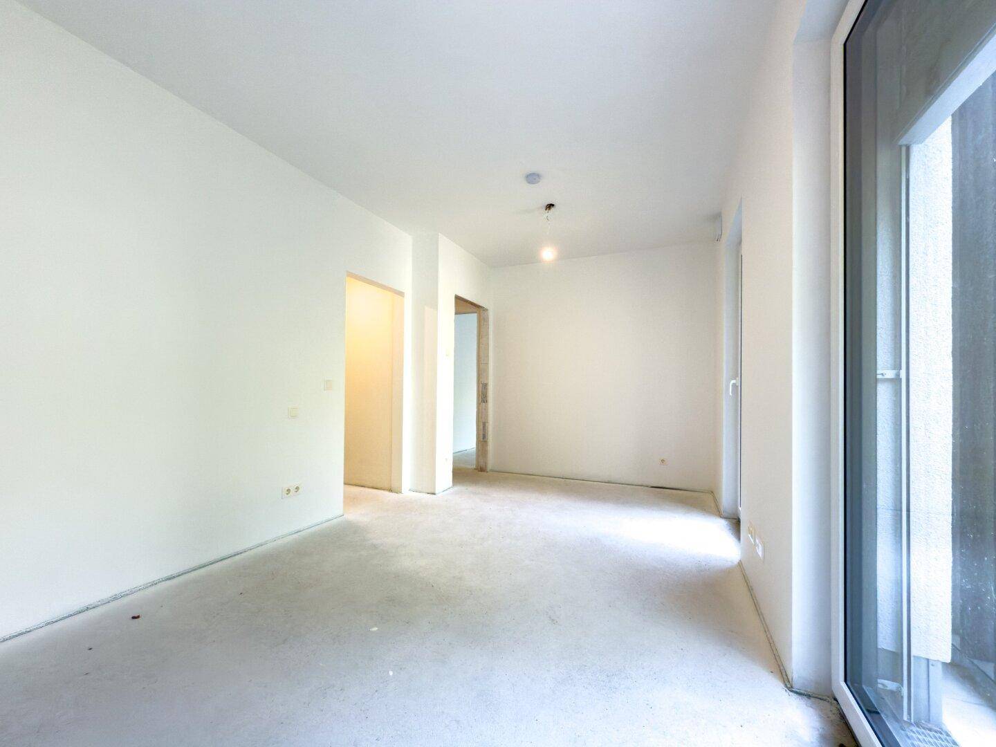 Leerer Raum mit großen Fenstern und viel Tageslicht, bereit für die individuelle Gestaltung.