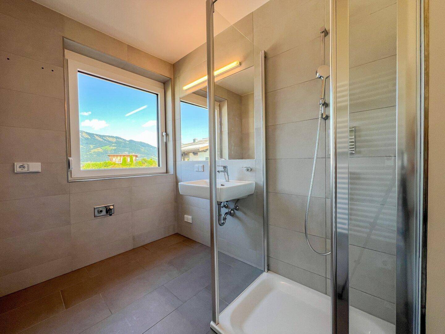 Badezimmer mit Dusche und Waschmaschinenanschluss