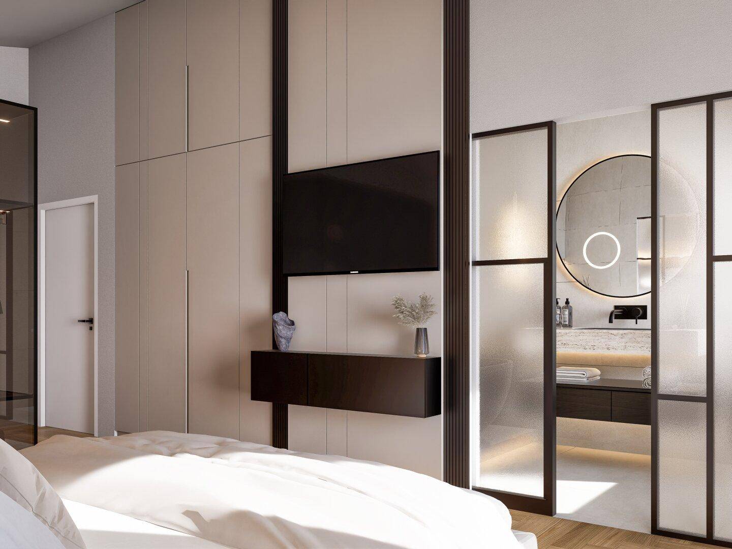 Schlafzimmer mit Einbauschränken und Zugang zu einem modernen Bad mit Rundspiegel.