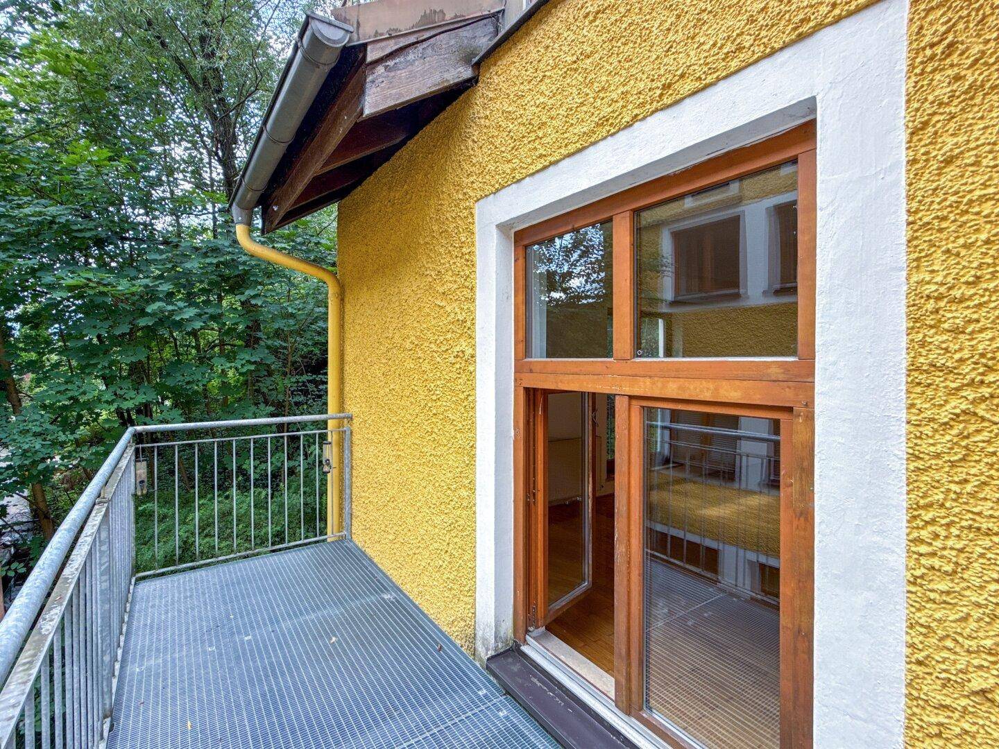 Kleiner Balkon mit Metallgeländer und Blick ins Grüne, ideal für frische Luft.