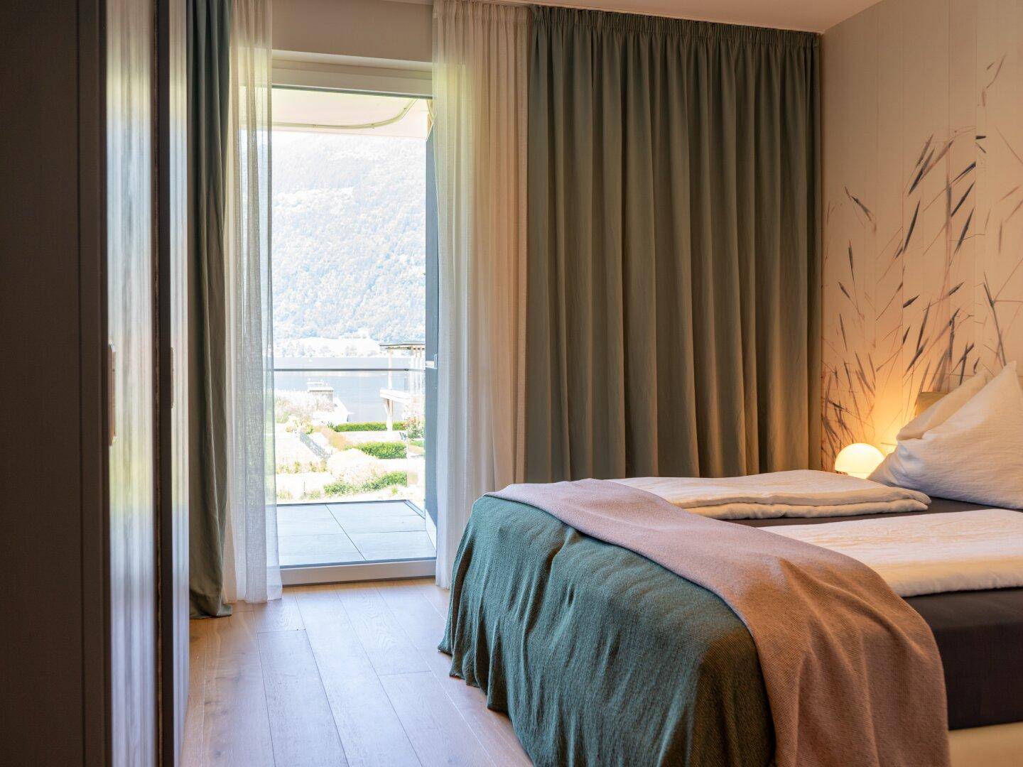 Helles Schlafzimmer mit Holzboden und Zugang zum Balkon, bietet einen schönen Blick auf die Landschaft.