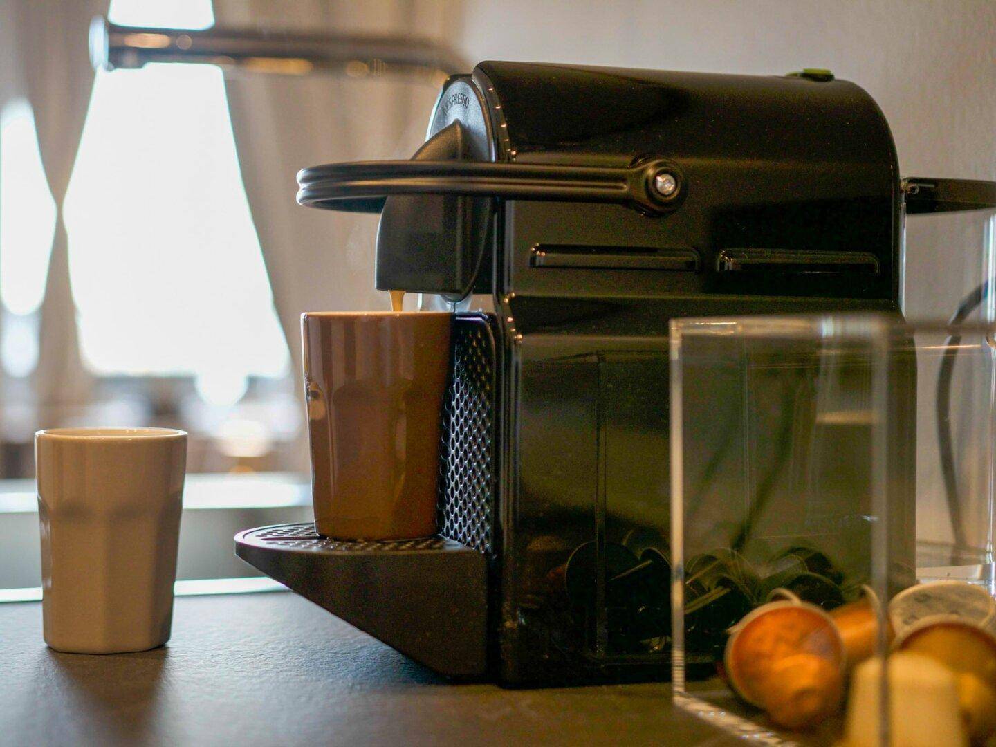 Detailaufnahme einer Kaffeemaschine auf der Küchenarbeitsplatte mit Tasse.