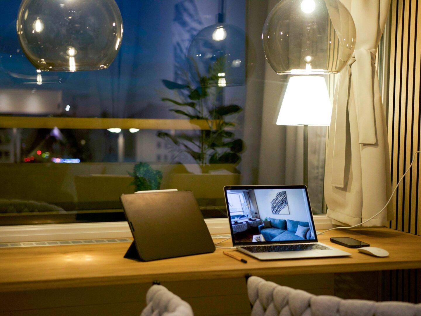 Flexibler Arbeitsbereich am Fenster mit Laptop, Tablet und Blick nach draußen.