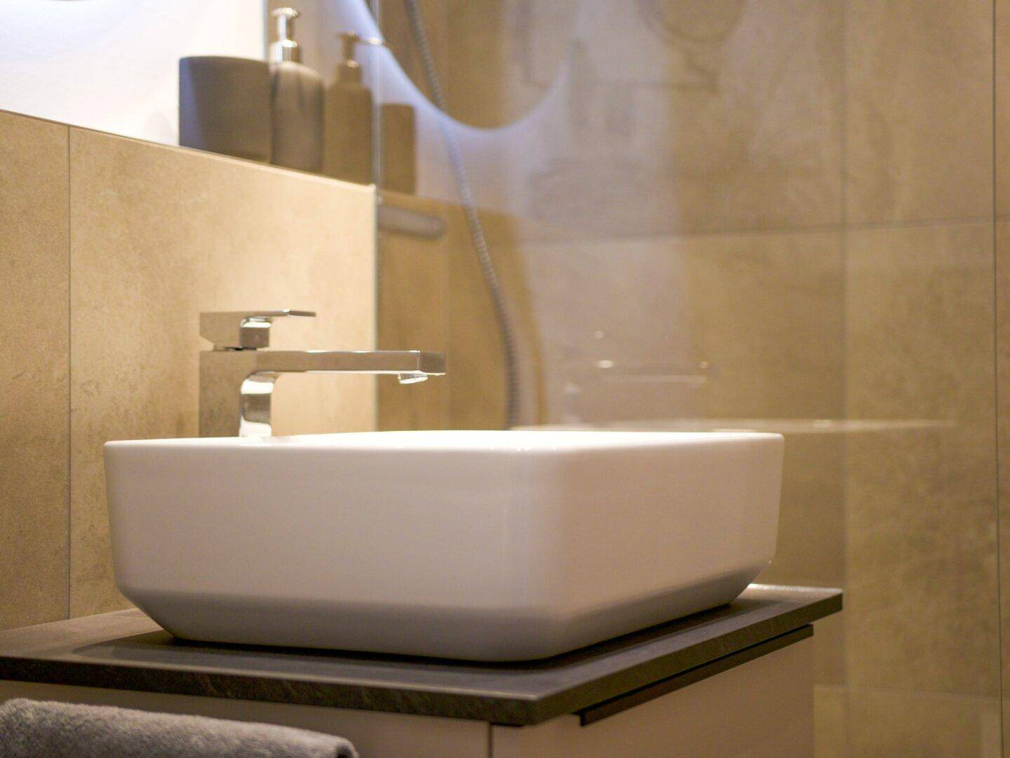 Detailaufnahme des modernen Aufsatzwaschbeckens mit elegantem Wasserhahn im Badezimmer.