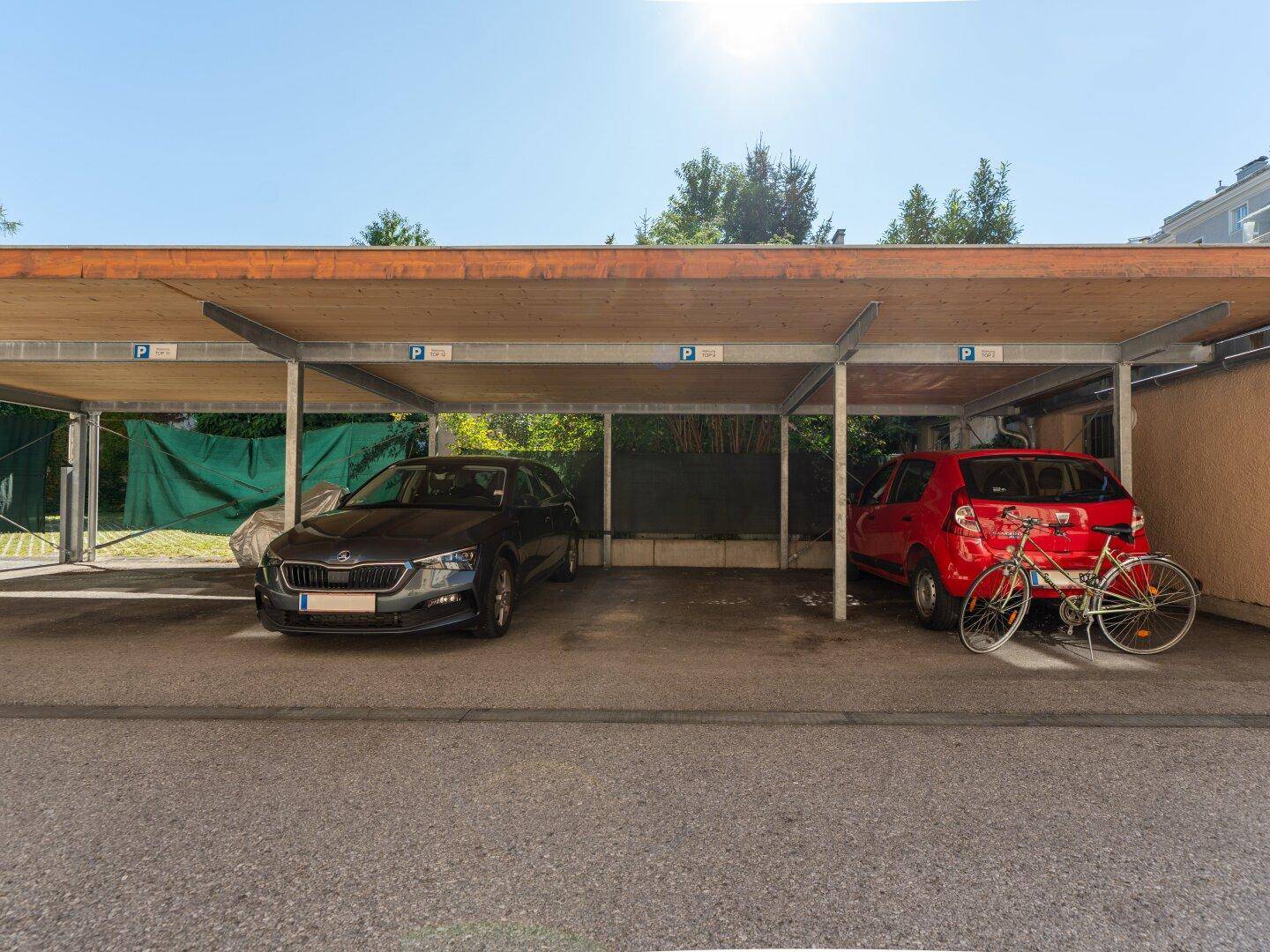 Überdachter Carport mit zwei Stellplätzen für Fahrzeuge im Freien.