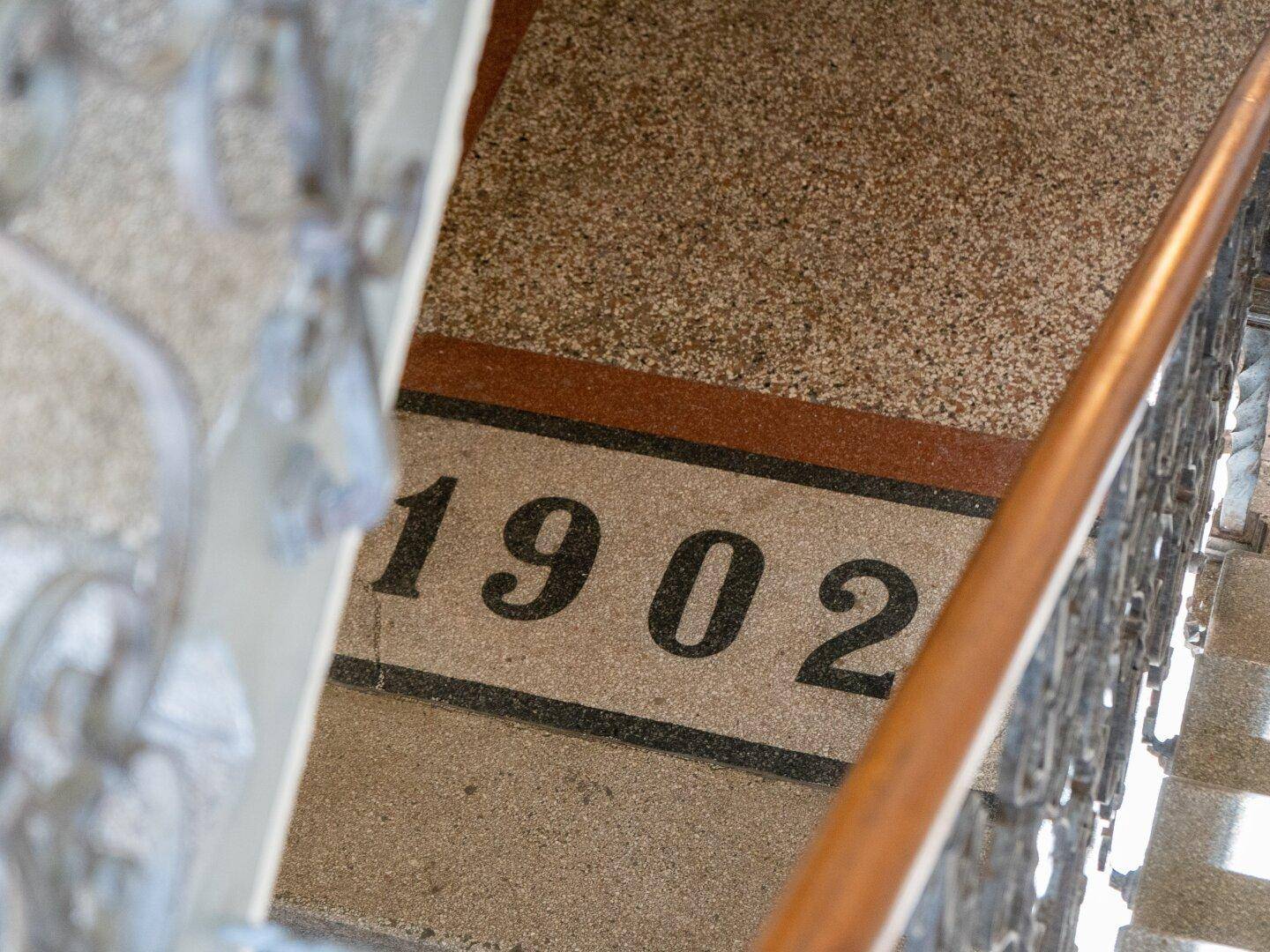 Detailaufnahme des Terrazzobodens im Treppenhaus mit der Jahreszahl "1902".