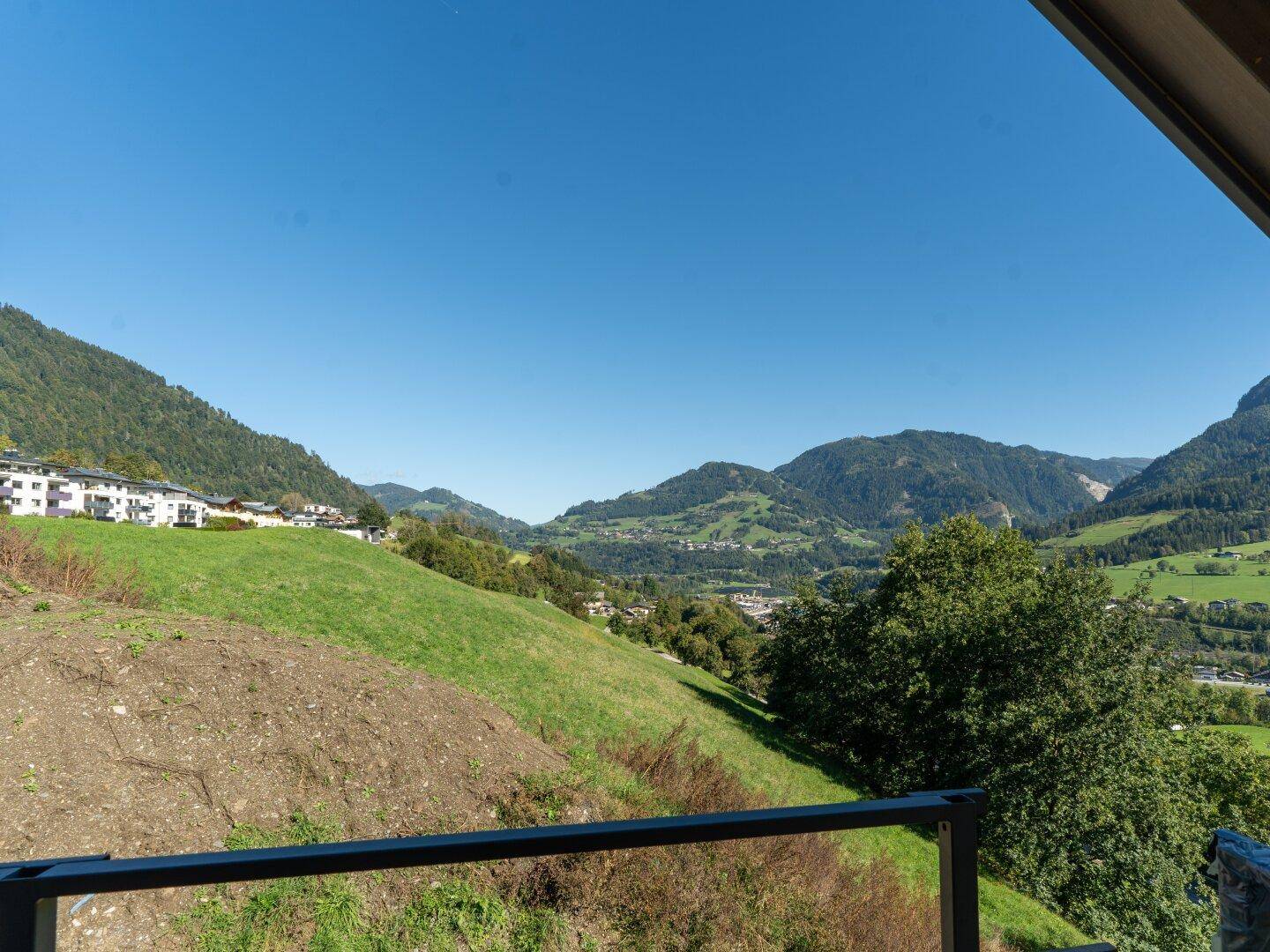 Panoramablick von einem Balkon oder einer Terrasse auf die grüne Berglandschaft.