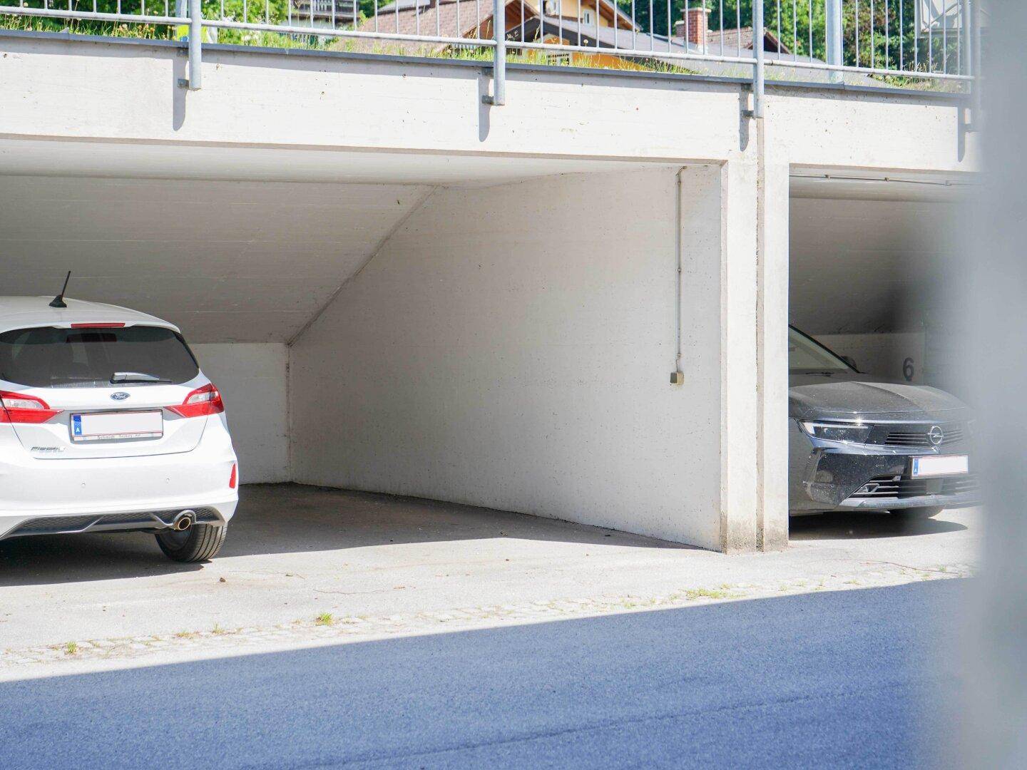 Tiefgarage mit zwei geparkten Autos, bietet sicheren und geschützten Stellplatz für Fahrzeuge.