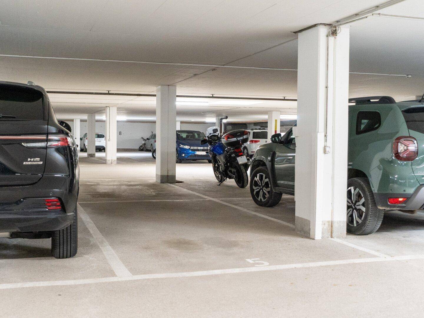 Geräumige Tiefgarage mit mehreren Stellplätzen für Fahrzeuge und Motorräder.
