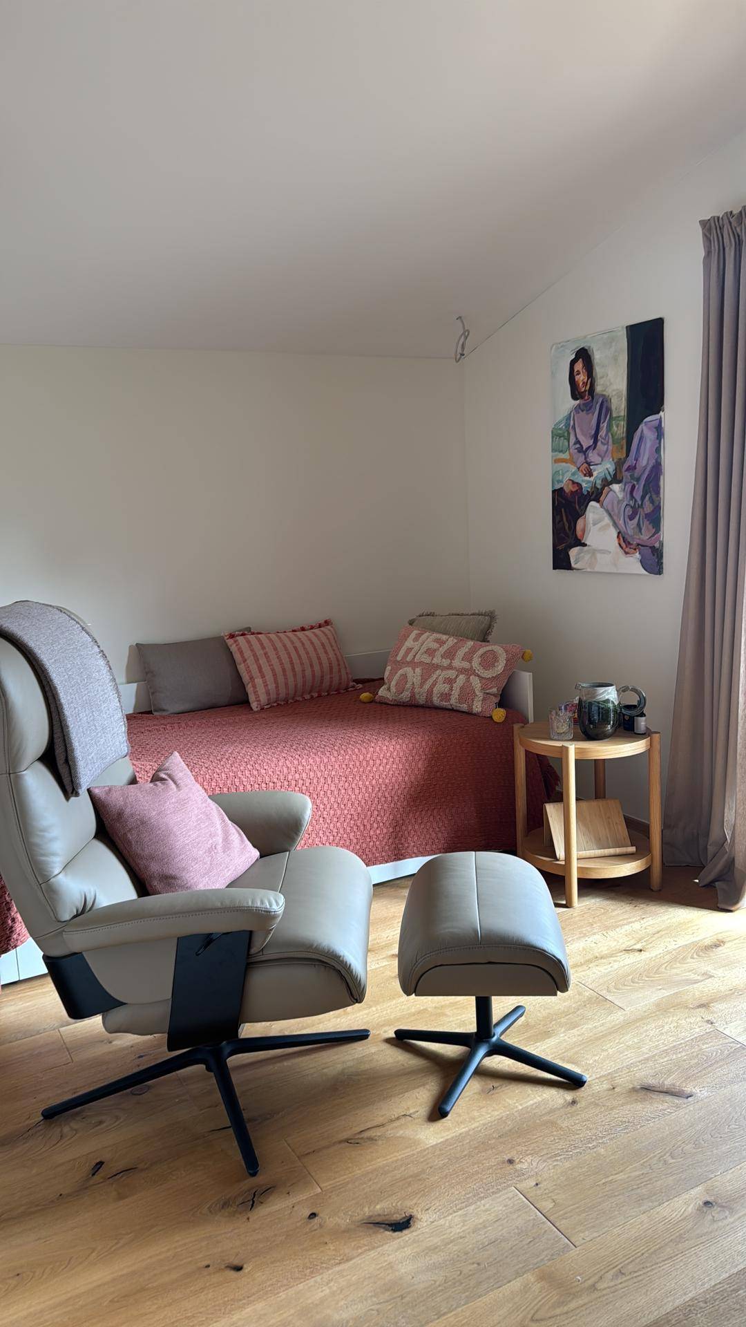 Gemütliches Zimmer mit Tagesbett, bequemen Sessel und Holzboden.