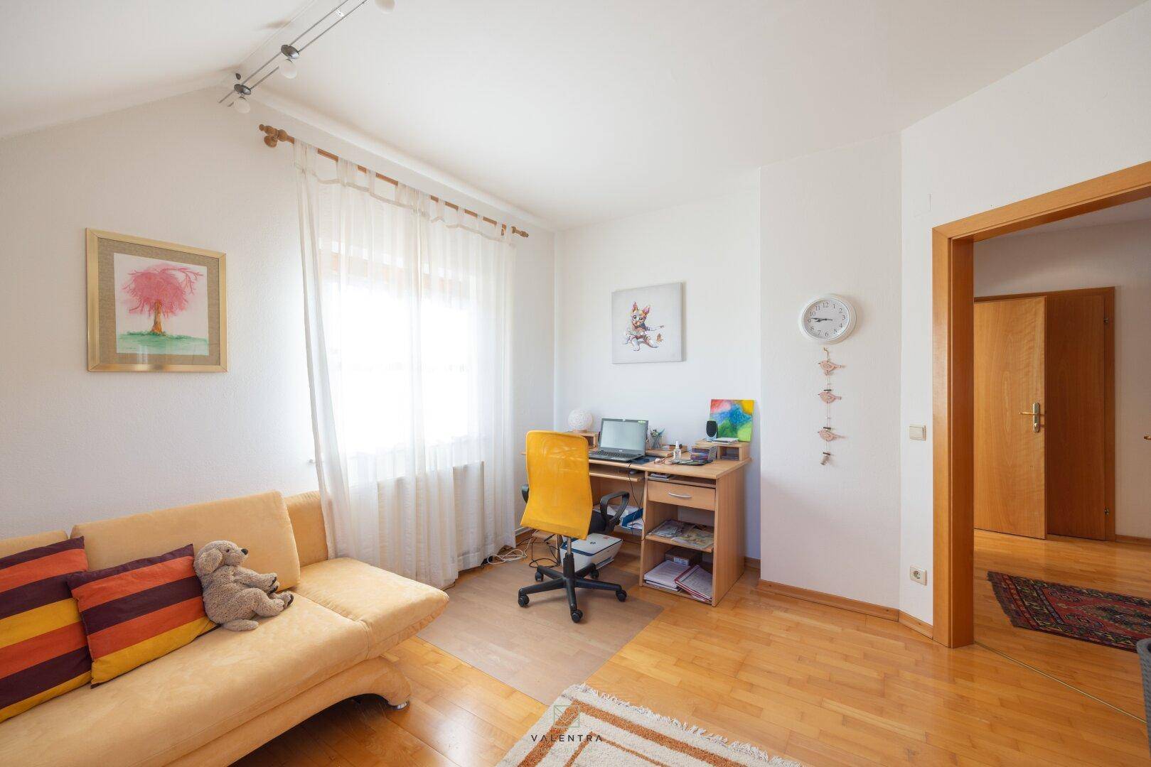 Arbeitsbereich mit Schreibtisch, Sofa und Fenster, ideal für Home-Office unter der Dachschräge.