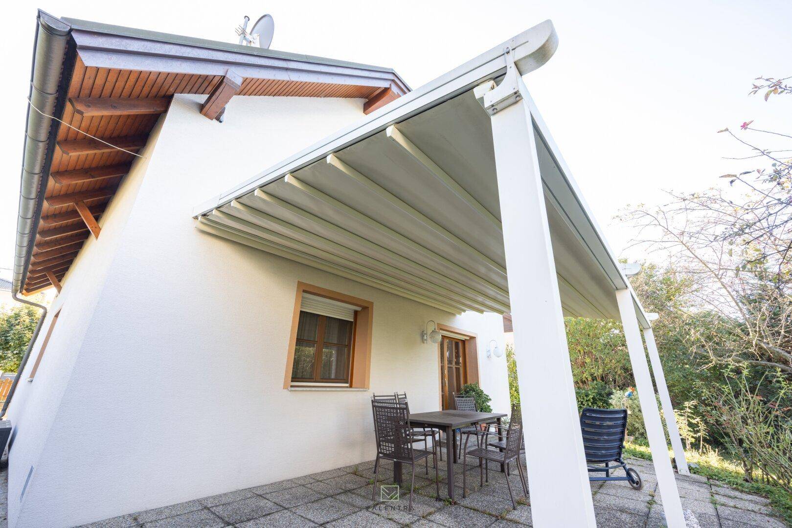 Überdachte Terrasse mit modernen Gartenmöbeln, ideal für entspannte Stunden im Freien.