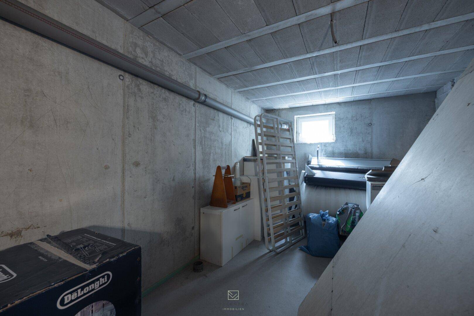 Kellerraum mit Betonwänden und kleinem Fenster, bietet zusätzlichen Stauraum für das Haus.