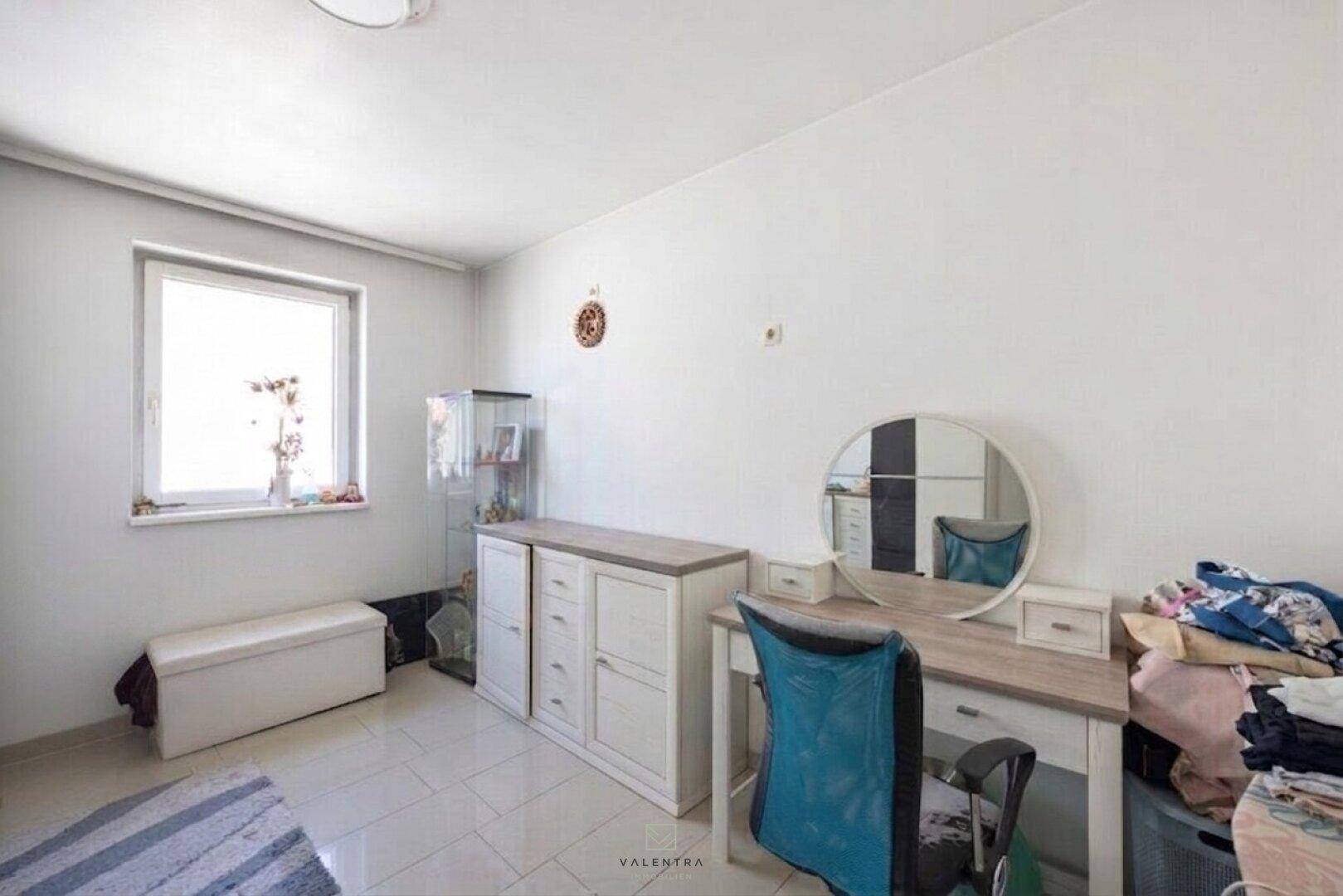 Helles Zimmer mit Schreibtisch, Schminktisch und Fenster, nutzbar als Büro oder Gästezimmer.