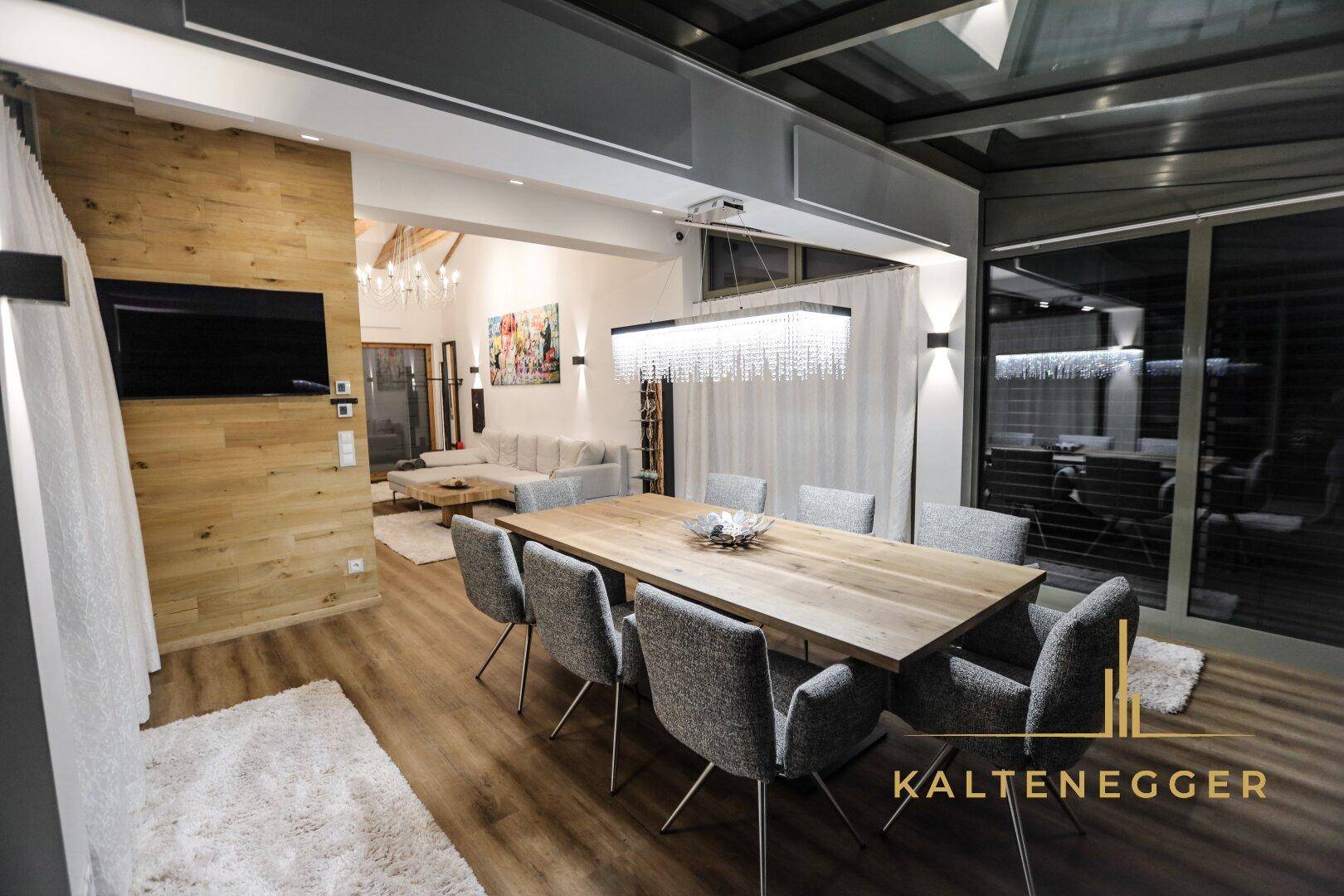 Eleganter Essbereich mit großem Holztisch, modernen Stühlen und Kronleuchter.